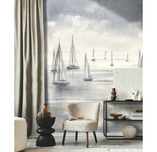 Woonkamer met een maritiem fotobehang met zeilboten in schetsstijl, een lichte fauteuil en een moderne open kast.