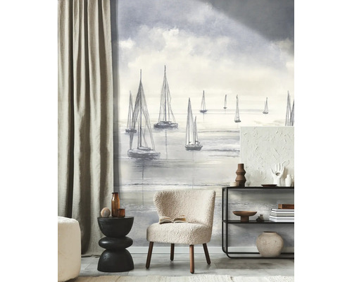 Woonkamer met een maritiem fotobehang met zeilboten in schetsstijl, een lichte fauteuil en een moderne open kast.