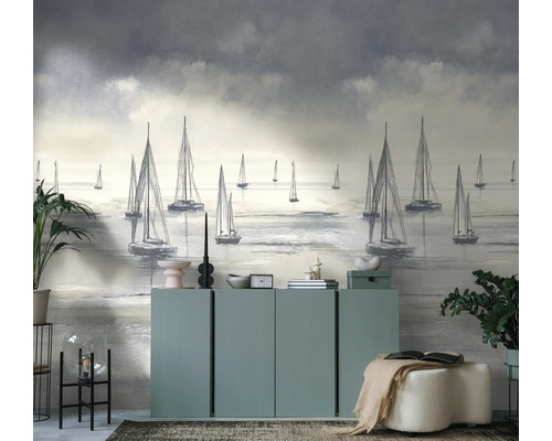 Modern fotobehang met een artistiek motief van zeilboten op zee onder een bewolkte hemel in een lichte woonkamer.