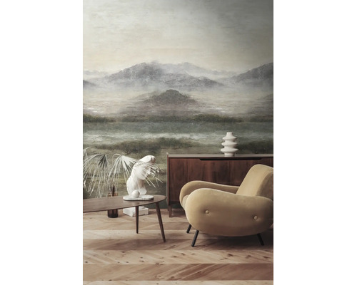 Fotobehang met berglandschap in een modern ingerichte woonkamer met fauteuil, houten dressoir en parketvloer.