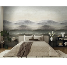 Moderne slaapkamer met een grote fotobehang met een mistig berglandschap. Inclusief tweepersoonsbed met beige beddengoed en een vloerkleed.