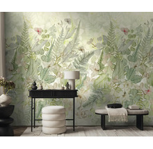 Vliesbehang met botanisch patroon van varens en bladeren in een lichte kamer met zwarte consoletafel, witte poef en een bank.