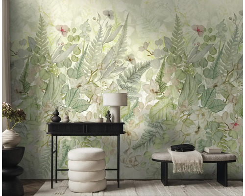 Vliesbehang met botanisch patroon van varens en bladeren in een lichte kamer met zwarte consoletafel, witte poef en een bank.