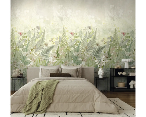 Moderne slaapkamer met botanisch fotobehang, blad- en varenmotieven in zachte groentinten achter een bed met beige beddengoed.