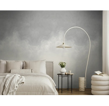 Moderne slaapkamer met grijs patroonbehang, licht bed, een booglamp en een ronde bijzettafel op een houten vloer.