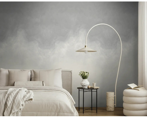 Moderne slaapkamer met grijs patroonbehang, licht bed, een booglamp en een ronde bijzettafel op een houten vloer.