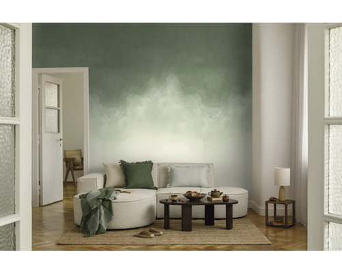 Fotobehang met groen-wit kleurverloop in een moderne woonkamer met een lichte bank, donkere salontafel en jute tapijt.