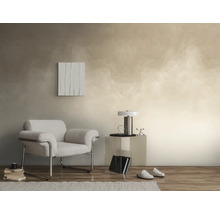 Moderne woonkamer met gestructureerd wandontwerp in beige, grijze fauteuil met chromen frame, transparante bijzettafel en parketvloer.
