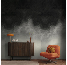 Vliesbehang met abstract, donker wolkenpatroon en kleurverloop in een moderne woonkamer met dressoir en fauteuil.