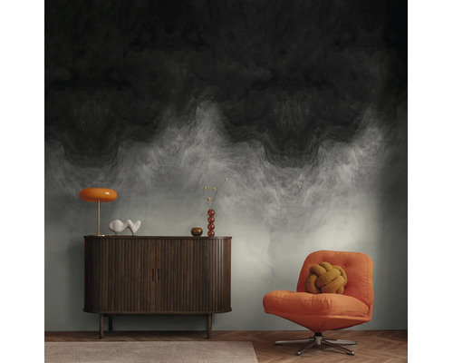 Vliesbehang met abstract, donker wolkenpatroon en kleurverloop in een moderne woonkamer met dressoir en fauteuil.