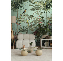 Tropisch fotobehang met palmen, vogels en bloemen in een woonkamer met witte fauteuil en glazen tafel.