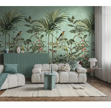 Fotobehang met jungle-motief, palmbomen en vogels achter een moderne witte bank in een lichte woonkamer.