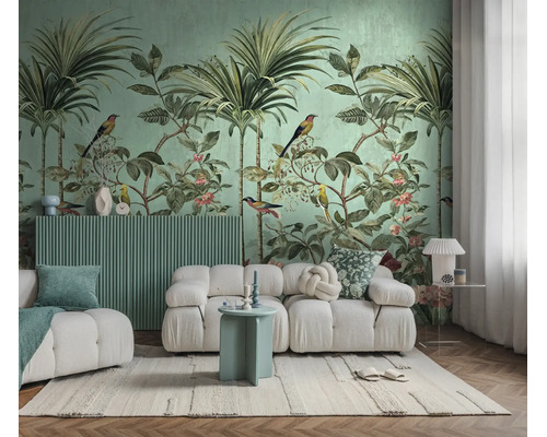 Fotobehang met jungle-motief, palmbomen en vogels achter een moderne witte bank in een lichte woonkamer.