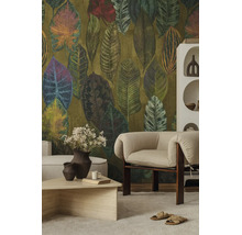 Vliesbehang met groot bladpatroon in natuurtinten in een modern ingerichte woonkamer met een lichte fauteuil en salontafel.