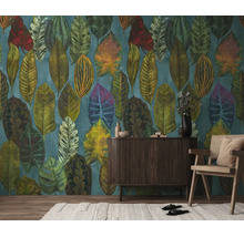 Vliesbehang met groot tropisch bladpatroon in diverse kleuren achter een donker dressoir en een houten stoel.