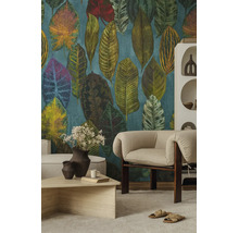 Vliesbehang met groot patroon van tropische bladeren in een modern ingerichte woonkamer met een beige fauteuil en salontafel.