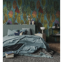 Slaapkamer met behang met grote bladmotieven, bed met geribbeld hoofdbord, blauw beddengoed en een grijs getextureerd tapijt.