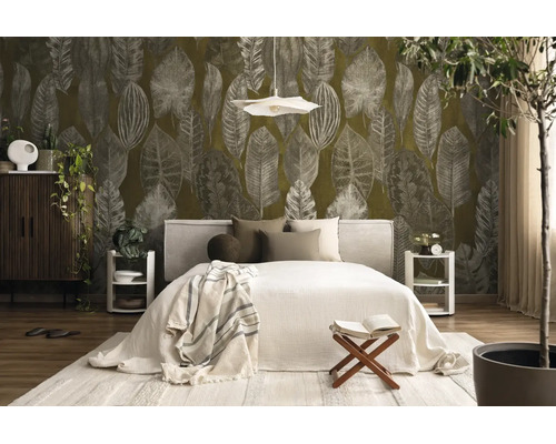 Slaapkamer met groot behang met bladmotief, tweepersoonsbed met licht textiel en moderne houten meubels op een licht tapijt.