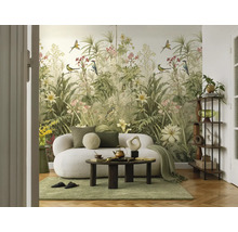 Woonkamer met botanisch fotobehang met vogels en planten, een witte bank en een ronde salontafel.