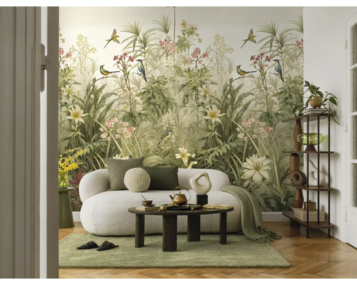 Woonkamer met botanisch fotobehang met vogels en planten, een witte bank en een ronde salontafel.