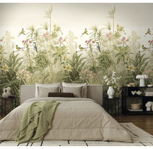Vliesfotobehang met botanisch patroon, diverse planten en vogels in een lichte slaapkamer met een beige bed.