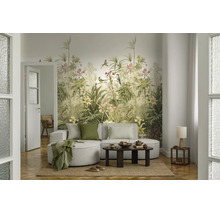Fotobehang met botanisch motief, tropische planten, vogels en bloemen in een modern ingerichte woonkamer met lichte bank en houten tafel.