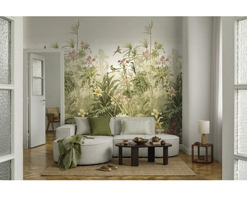 Fotobehang met botanisch motief, tropische planten, vogels en bloemen in een modern ingerichte woonkamer met lichte bank en houten tafel.