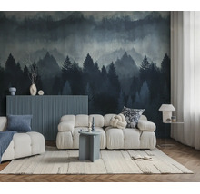 Een moderne woonkamer met een witte modulaire bank en een fotobehang met een mistig naaldbos in blauwe en grijze tinten.