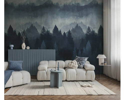Een moderne woonkamer met een witte modulaire bank en een fotobehang met een mistig naaldbos in blauwe en grijze tinten.