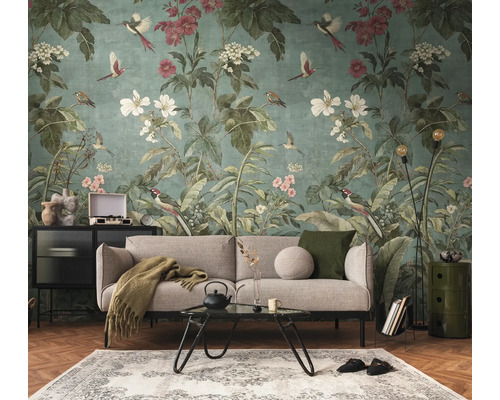 Fotobehang met floraal patroon en vogels in een modern ingerichte woonkamer met bank en salontafel.