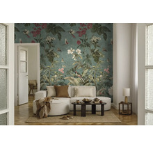 Vliesfotobehang met botanisch patroon, vogels en bloemen in een licht ingerichte woonkamer met een lichte bank en een donkere salontafel.