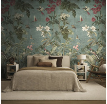 Fotobehang met bloemen- en vogelmotief achter een bed in een modern ingerichte slaapkamer met textiel in natuurtinten.