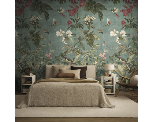 Fotobehang met bloemen- en vogelmotief achter een bed in een modern ingerichte slaapkamer met textiel in natuurtinten.