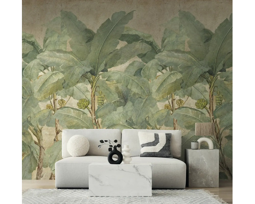 Fotobehang met grote bananenbladeren in een modern ingerichte woonkamer met een lichte bank en marmeren tafel.