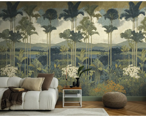 Vliesbehang met jungle-motief, palmbomen en bergen achter een witte bank in een modern ingerichte woonkamer.