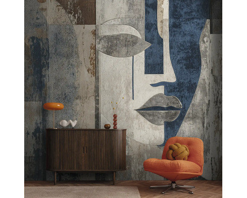Moderne woonkamerwand met groot formaat fotobehang van een abstract gezicht, donker houten dressoir en oranje fauteuil.