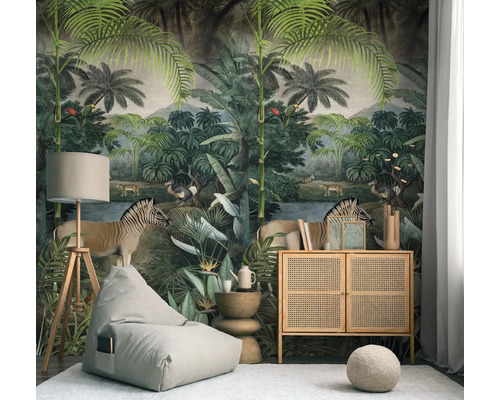 Lichte woonkamer met jungle fotobehang, palmen en dieren. Ingericht met zitzak, rotan dressoir en een houten vloerlamp op tapijt.