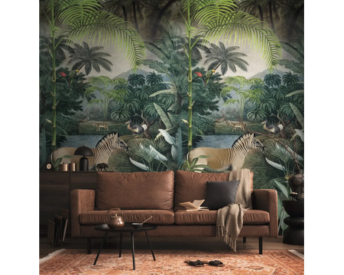 Behang met jungle-motief, zebra's en palmbomen in een woonkamer achter een bruine leren bank.