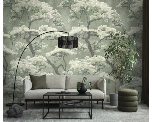 Vliesbehang met boommotief in moderne woonkamer met bank, zwarte salontafel, vloerlamp en kamerplant.