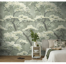 Vliesbehang met Japans boompatroon in een slaapkamer achter een bed en een wit nachtkastje.