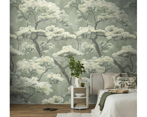 Vliesbehang met Japans boompatroon in een slaapkamer achter een bed en een wit nachtkastje.