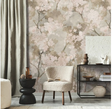 Fotobehang met verfijnd kersenbloesempatroon in een moderne kamer met een lichte fauteuil, zwarte bijtafel en rek.