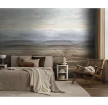Slaapkamer met fotobehang van een berglandschap in bruin en blauw, ingericht met een bed en een houten stoel.