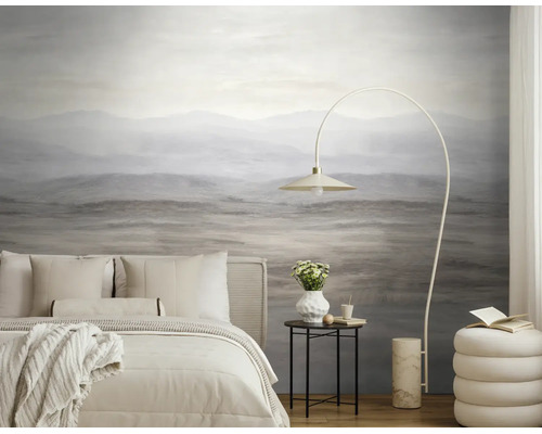 Modern fotobehang met berglandschap in een lichte slaapkamer met bed, booglamp en bijzettafel.