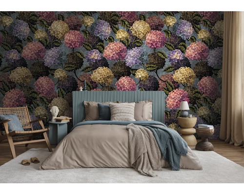 Slaapkamer met fotobehang met groot hortensia-bloemmotief, een tweepersoonsbed en een houten fauteuil op een tapijt.