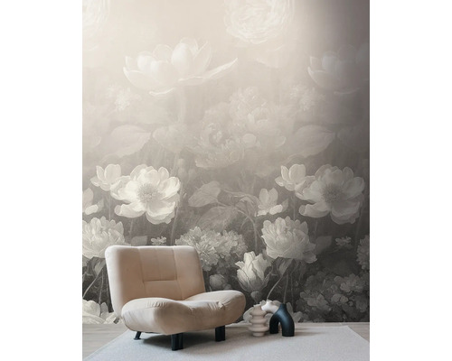 Fotobehang met groot bloemenpatroon in vintage stijl, beige beklede fauteuil op licht tapijt in een lichte kamer.