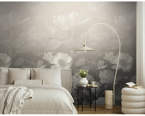Moderne slaapkamer met fotobehang met grote bloemmotieven in grijstinten, een licht bed, een booglamp en een bijzettafel.