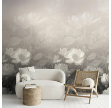 Vliesfotobehang met groot bloemenpatroon in een modern ingerichte woonkamer met witte bank, houten stoel en jute hocker.