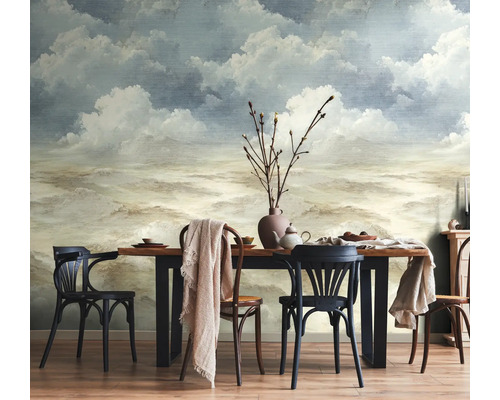 Fotobehang met een artistiek wolken- en luchtlandschap in een eetkamer met houten tafel en stoelen.