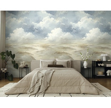 Fotobehang met een geschilderd landschap van wolken en heuvels in een moderne slaapkamer met beige bed en kamerplanten.